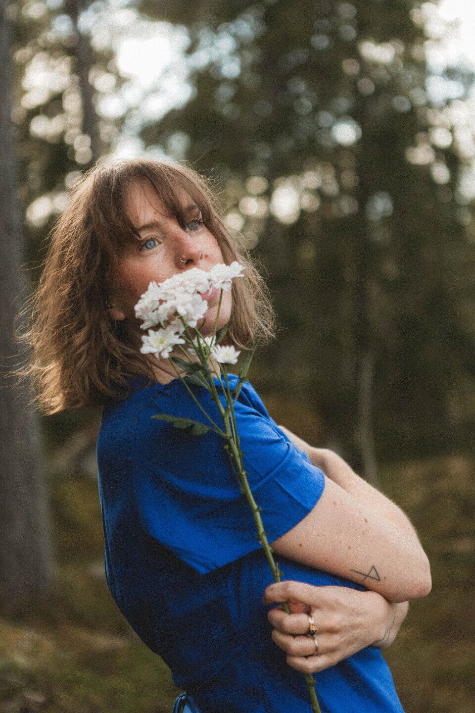 Hanna Ideäng in the forest holding white flowers